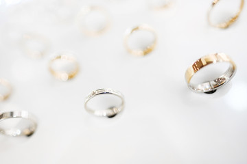 Gold jewelry ring, a lot of the exhibition on the stand in the store on a white background, close-up.