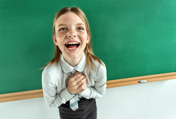 Humorous high angle view of Happy joyful laughing beautiful girl with hands clasped together