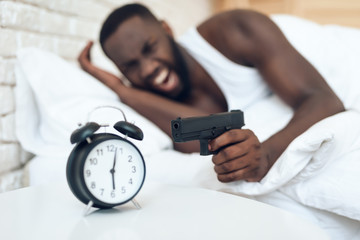 African American angry man with gun aims