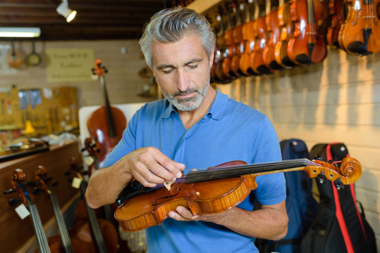 Luthier inspecting violin