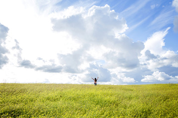 Fototapeta premium happy girl in a yellow flower field with a dandelion in her hand