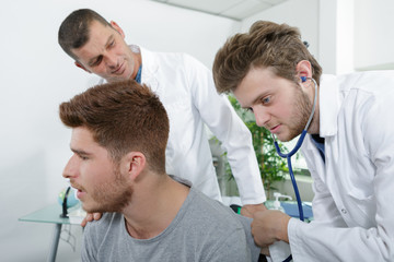 young internist healing patient under experienced doctors surveillance