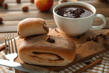 Sweet cinnamon buns on wooden board