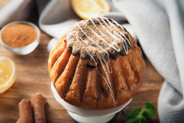 Stand with sweet cinnamon cake on wooden table