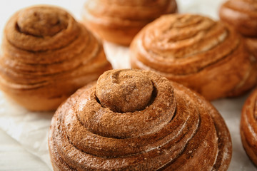 Sweet cinnamon buns on table, closeup