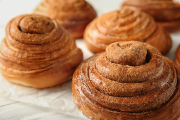 Sweet cinnamon buns on table, closeup