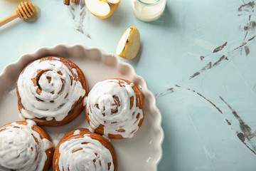Dish with glazed cinnamon buns on table