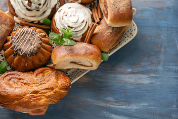 Tray with sweet cinnamon buns on wooden table