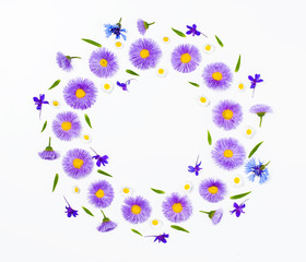 Floral wreath made of violet flowers and chamomile on white background. Flat lay. Top view with copy space.