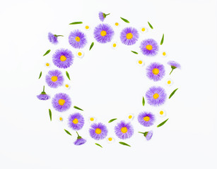 Floral wreath made of violet flowers and chamomile on white background. Flat lay. Top view with copy space.