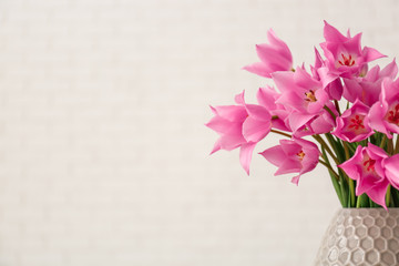Vase with beautiful tulips on light background
