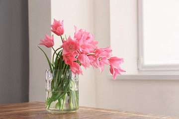 Vase with beautiful tulips on table indoors