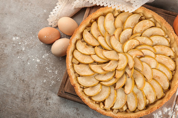 Wooden board with tasty homemade apple pie on table