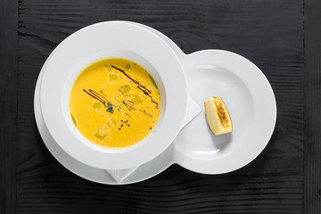 Pumpkin cream soup on wooden background. Top view