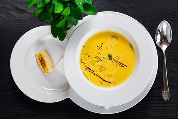Pumpkin cream soup on wooden background. Top view