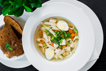 Tasty chicken broth on wooden background. Top view