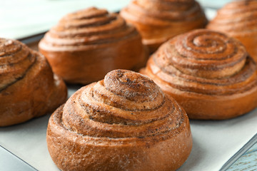 Sweet cinnamon buns on table, closeup
