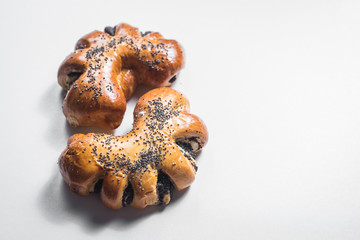 Sweet bun with poppy seed on white background. Top view. Copy space