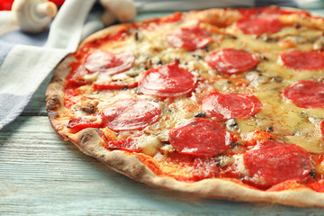 Tasty Italian pizza on wooden table, closeup