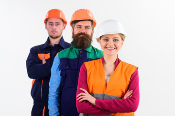 Woman and men in hard hats stand close as team.