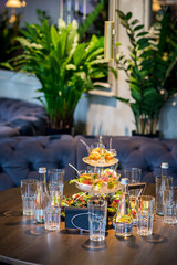 Tasty little snacks with meat and vegetables on served table at the restaurant