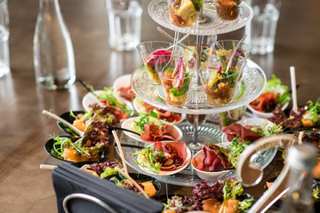 Tasty little snacks with meat and vegetables on served table at the restaurant