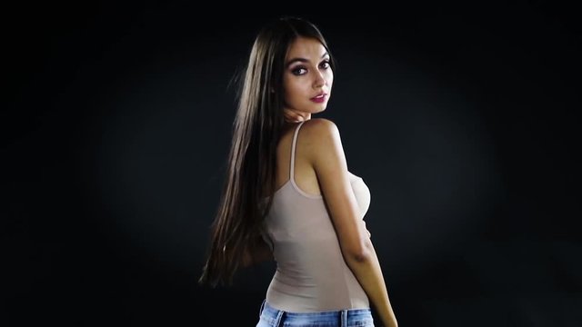 Beautiful young brunette in studio on a black background.
Slow motion movie