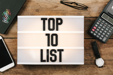 Text Top 10 written in vintage style light box on office deskt op