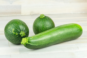 Varieties of green zucchini on wooden table