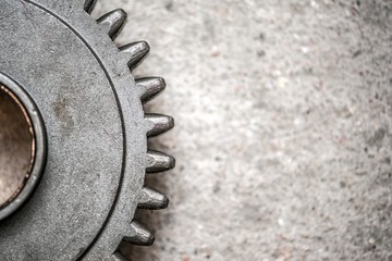 Steel gears on grey concrete background with copy space. Close up