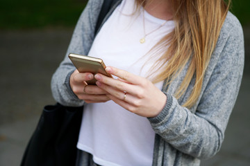 young woman using smartphone or mobile phone outdoors