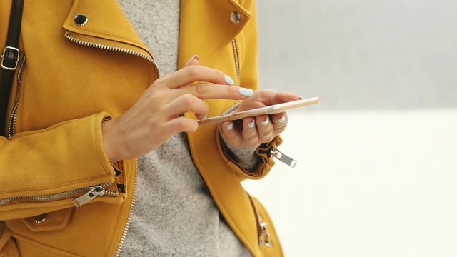 close up view of young female hands using smart phone outdoor casual fashionable clothes online shopping internet searching traveling business startup trendy freelance lifestyle checking notification