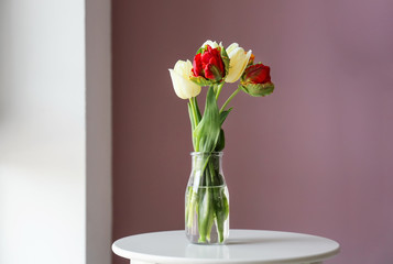 Vase with beautiful tulips on table indoors