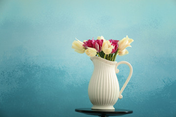 Vase with beautiful tulips on color background