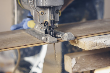 Professional work on laying the laminate, the working process of installing floor coverings, cutting with an electric jigsaw