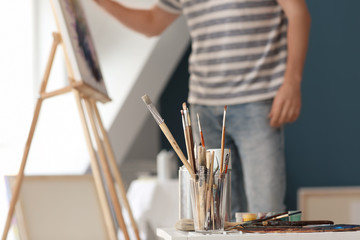 Obraz premium Table with paint tools in artist's workshop