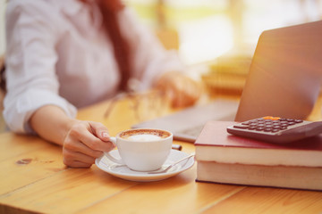 Selective focus. Woman with a cup of coffee in hand.