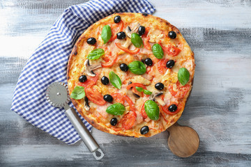 Board with tasty Italian pizza and knife on wooden table