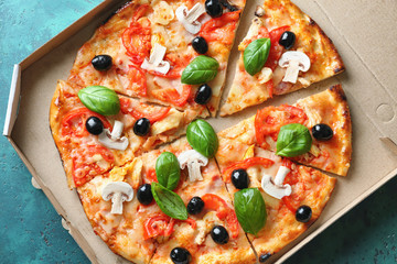 Box with tasty Italian pizza on color table