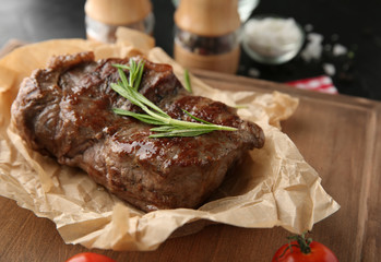 Tasty grilled steak on wooden board, closeup