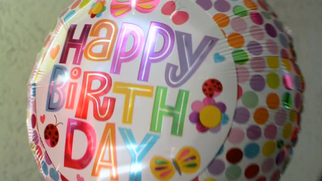 Clown wearing white gloves is gifting a hapy birthday party celebration balloon