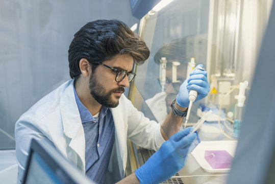Lab technician working with pipette in molecular laboratory