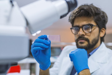 Researcher holding a microscope slide