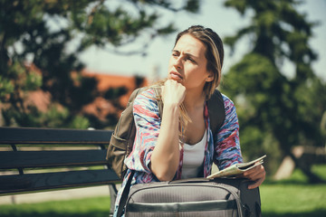 Fototapeta premium Young woman is going on vacation. She is waiting for her transportation. 