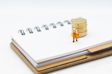 Miniature people: Worker use pallet truck with stack of coins. Image use for background business...