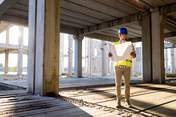 Picture of construction site engineer looking at plan