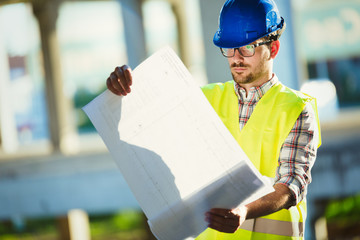 Picture of construction site engineer looking at plan