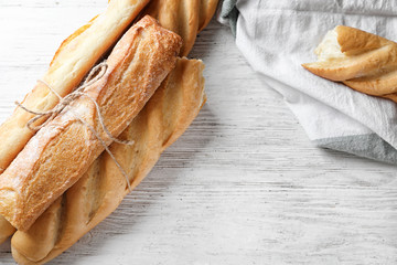 Different fresh tasty bread on white wooden table