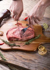 Hand cutting raw beef steak