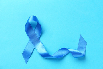 Blue ribbon on color background. Prostate cancer concept